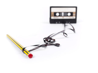 retro cassette with loose tape over a white background