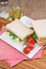 Fototapeta na wymiar Fresh egg and rocket on white sandwich in rustic kitchen setting