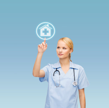 Smiling Doctor Or Nurse Pointing To Hospital Icon