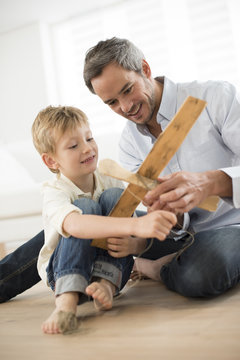 Father And Son Building A Wooden Model Plane