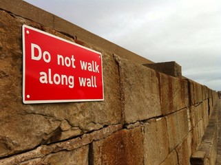 warning sign on harbour wall