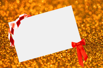 Christmas sheet of paper with bow on yellow defocused background