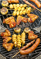 Grill mit Hühnchenflügel, Hühnchenspieß, Bratwurst, Zwiebel und