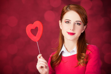Redhead girl with shape heart toy.