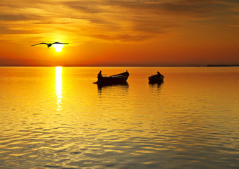 Naklejka na ściany i meble paseo en barca en la puesta de sol