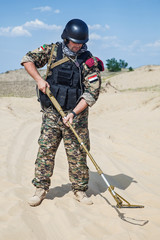 soldier with metal detector