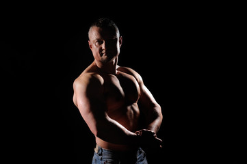 Obraz na płótnie Canvas Muscular male posing on black background