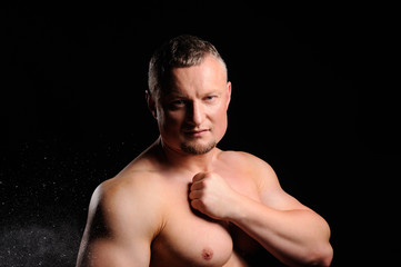Naklejka premium Muscular male posing on black background