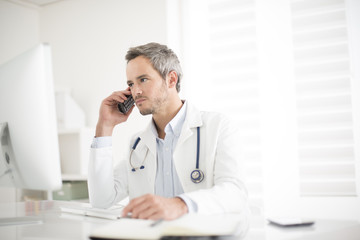 young doctor on phone at his office