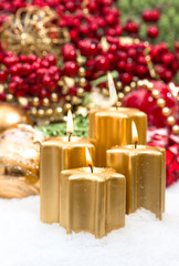 advent decoration in gold and red with four burning candles
