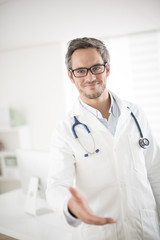 young doctor welcoming at his office