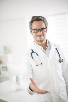 young doctor welcoming at his office