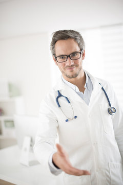 young doctor welcoming at his office