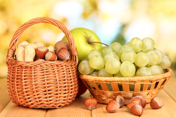 Grape in basket with nuts on wooden table
