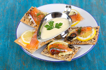 Salmon sandwiches on plate  on wooden table close-up