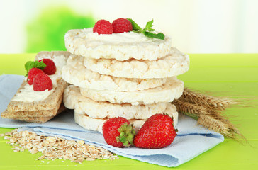 Tasty crispbread with berries, on green table