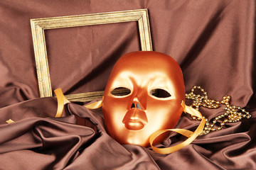 Mask on brown fabric background