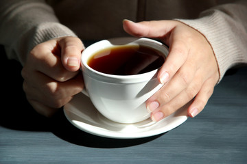 Hands holding mug of hot drink, close-up