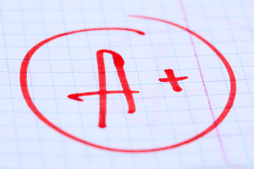 Grade A+ written on an exam paper