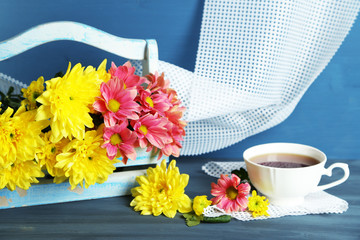 Beautiful flowers in basket, on dark wooden background