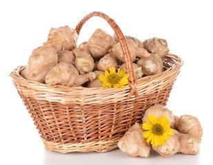 Topinambur roots in wicker basket isolated on white