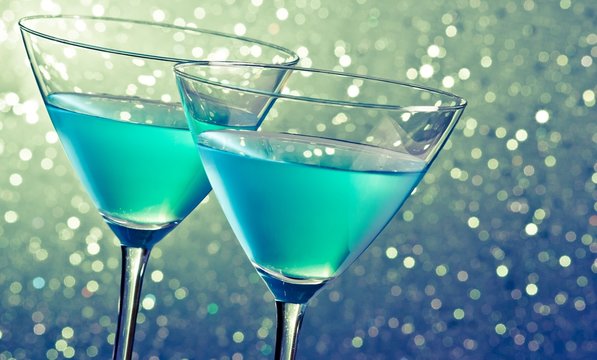 Two Glasses Of Blue Cocktail On Dark Green Tint Light Bokeh