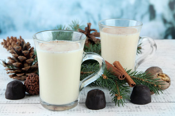 Cup of eggnog with fir branches and candies