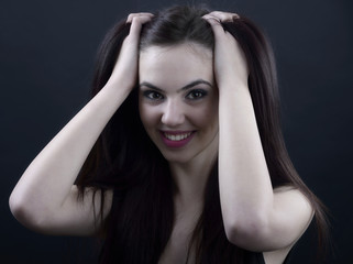 Fototapeta premium Portrait of a beautiful young woman in a black dress with a cool