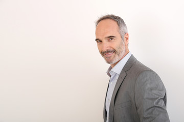 Cheerful senior businessman standing on white background