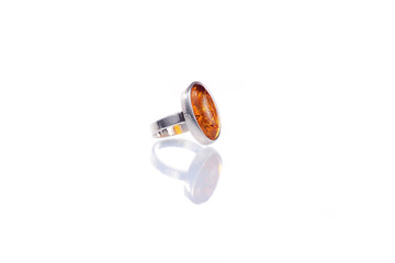 Silver ring with amber stone on white background with reflection