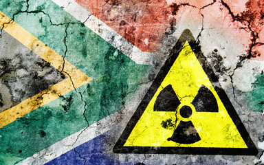 Old cracked wall with radiation warning sign and painted flag