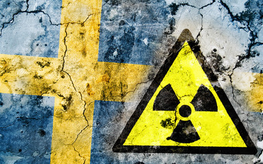 Fototapeta premium Old cracked wall with radiation warning sign and painted flag