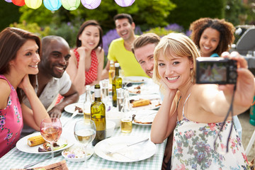 Friends Taking Self Portrait On Camera At Outdoor Barbeque