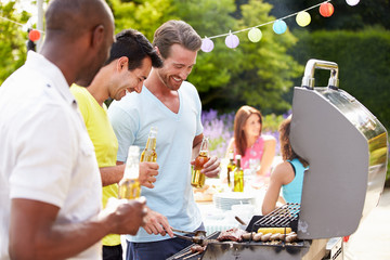 Group Of Men Cooking On Barbeque At Home