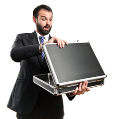 Young businessman open his briefcase over white background