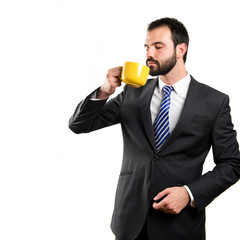 Young businessman drinking a coffee over white background