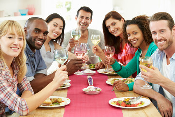Obraz na płótnie Canvas Group Of Friends Sitting Around Table Having Dinner Party