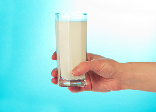 Glass of fresh cold milk in hand