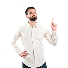 Young man pointing up over white background