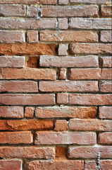 Muro irregolare di vecchi mattoni rossi vertilale