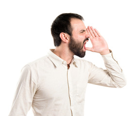 Young man screaming over white background