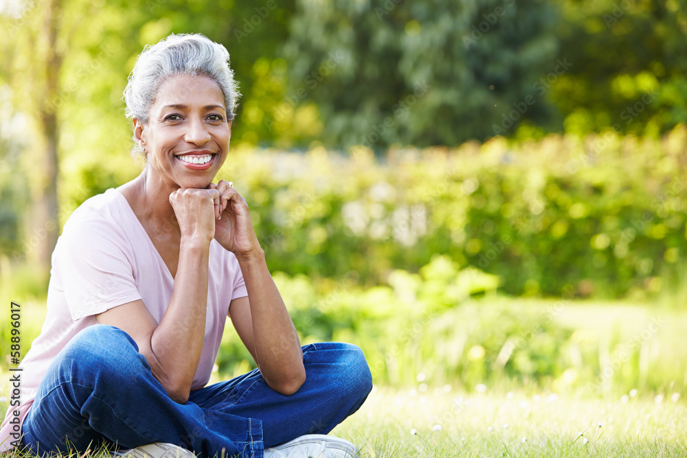 Wall mural Attractive Mature Woman Sitting In Garden