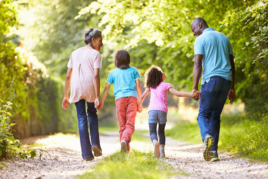 Grandparents With Grandchildren Walking Through Countryside - Powered by Adobe