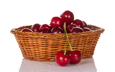 Fototapeta na wymiar Basket with sweet cherries and two berries nearby