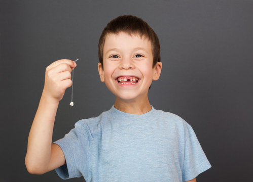boy show lost tooth on a thread