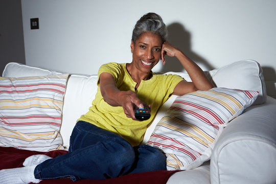 Mature African American Woman On Sofa Watching TV