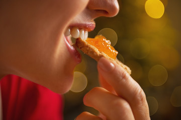Portrait of young woman eating cookie with orange jam - obrazy, fototapety, plakaty