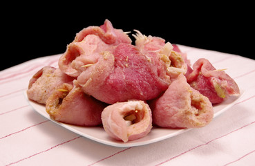 Raw stuffed pork slices on the table.