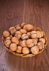 walnuts in a wicker basket on a wooden background