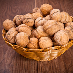 walnuts in a wicker basket on a wooden background